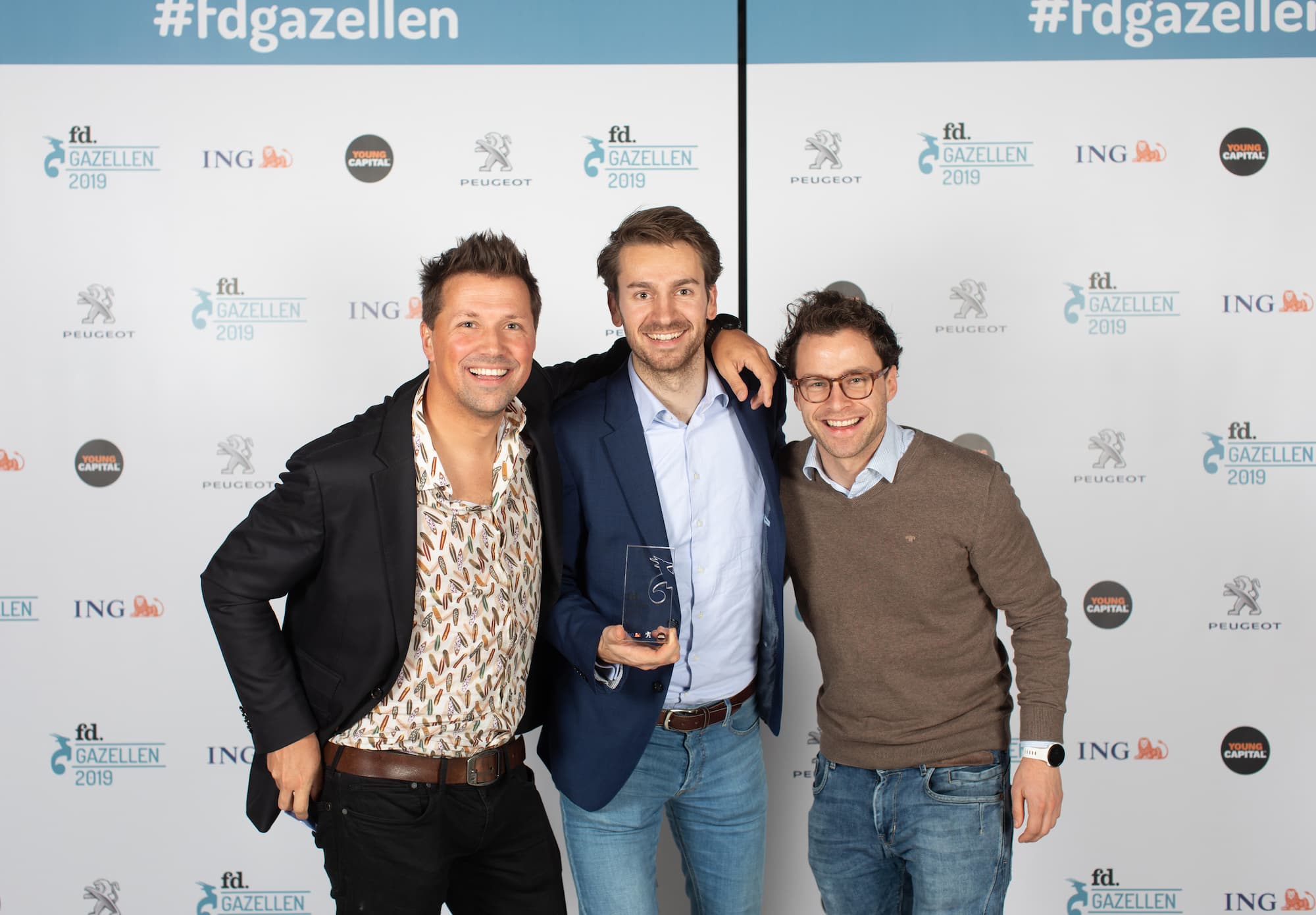 De drie eigenaren van Stuurlui — Hans, Thomas en Sjoerd — poseren samen glimlachend bij de uitreiking van hun eerste FD Gazellen Award in 2019. Ze staan voor een achtergrond met logo’s van FD Gazellen, ING, Peugeot en YoungCapital, en Thomas houdt de prijs vast.
